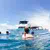 Group of snorkeler and tour boat