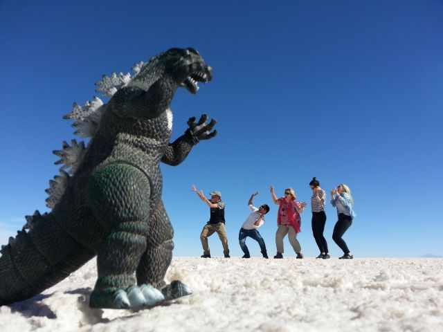 A small dinosaur apperears huge in front of five visitors.