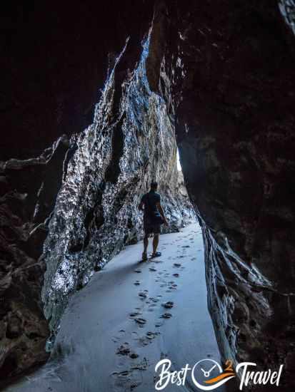 A man walking out of a cave at Adraga