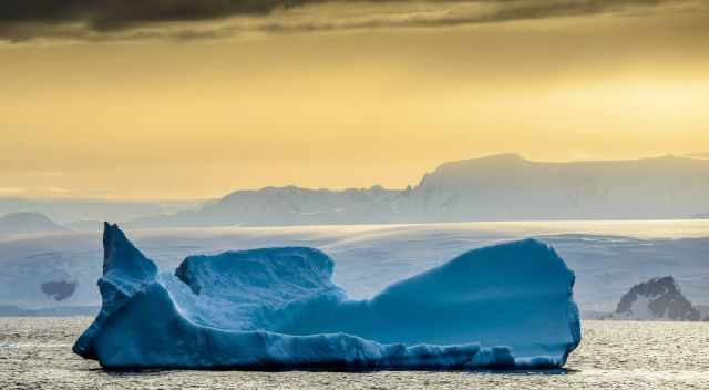 Smaller Iceberg in white and blue during sunset