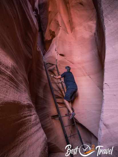 A hiker on the ladder into Fire Canyon