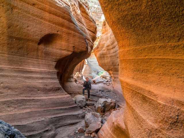 A visitor inside the orange shimmering caynon.