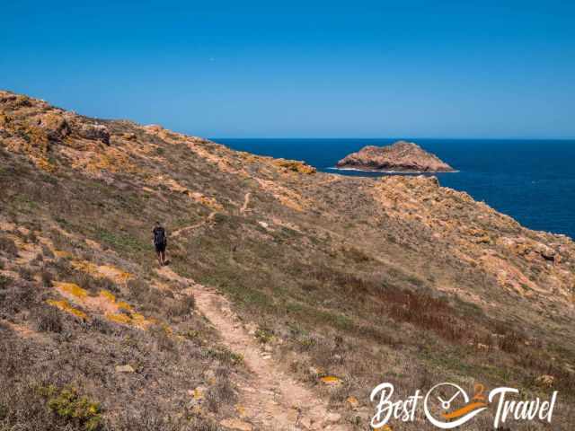 A hiker on a narrow path to Buzinas