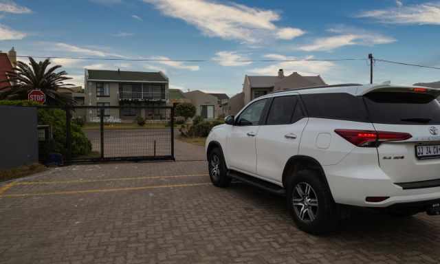 A car leaving the penguin area and the gate opens.