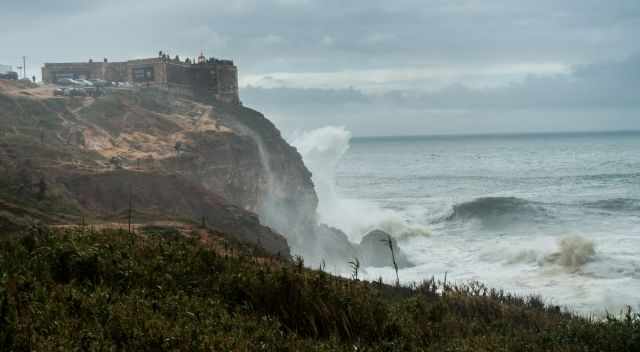 The lighthouse in front of the monster waves.