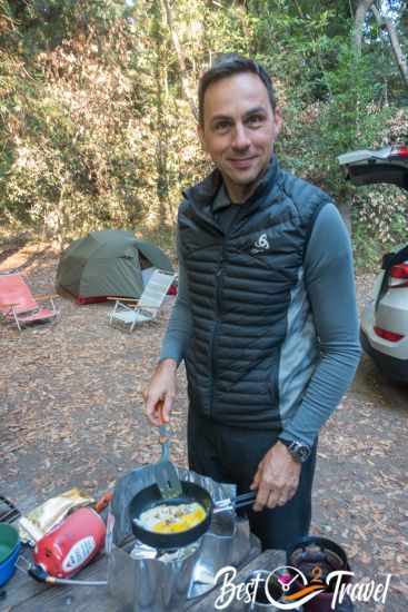 A camper is preparing eggs in the morning