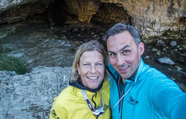 A couple in wetsuits after their adventure in the cave stream.