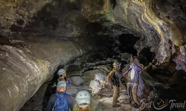 The guides and group in the cave looking to the interesting cave wall