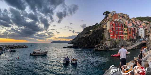 Visitors watching the sunset in Manarola from the cliffs and harbour