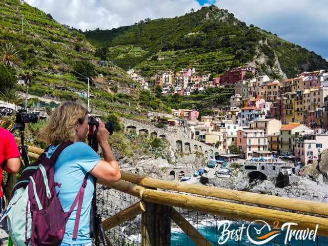 A woman is photographing with a tripod Manarola