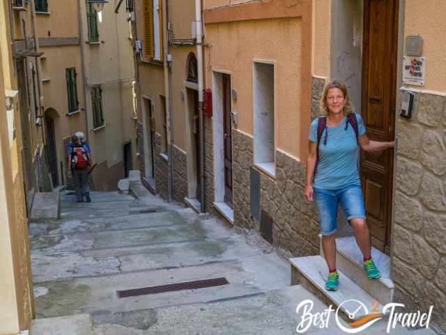 A woman at the entrance door of an apartment in an alley.