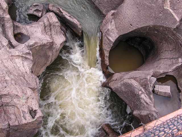 Potholes in the riverbed carved out by the immense flow.