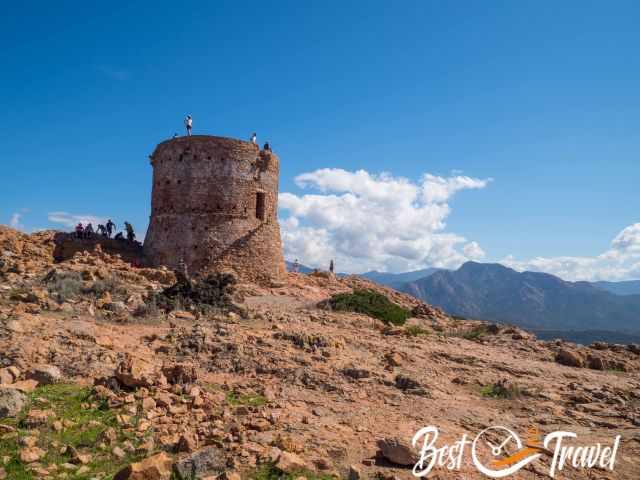 Lots of people-hikers on the watchtower Torra di Turghju.