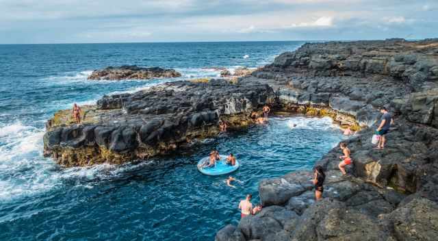 People swimming next to Queens Bath