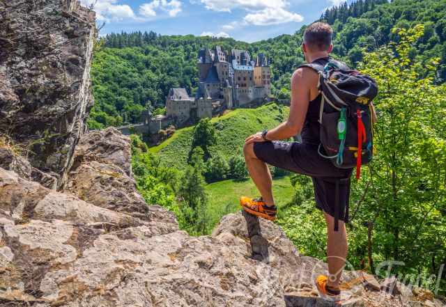 A hiker looking to Eltz Castle from a viewpoint