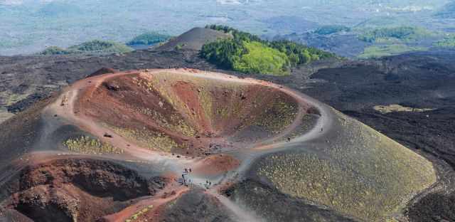 An crater in orange, red and light pink with growing mosses.