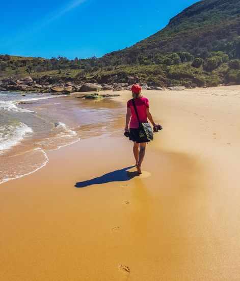 A woman walking barefoot on Burning Palms Beach