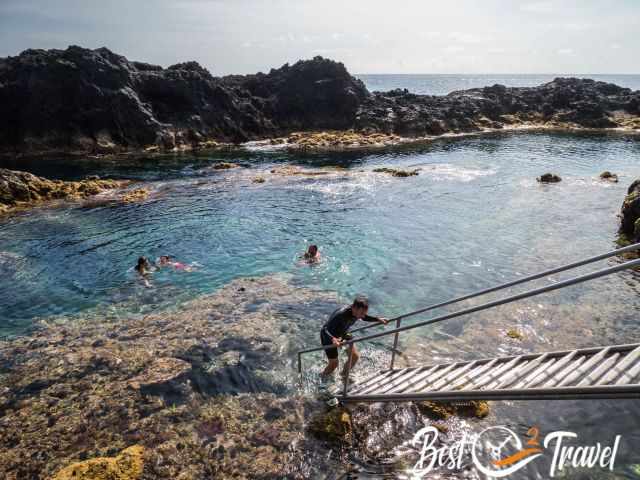 People swimming in a natural swimming pool.