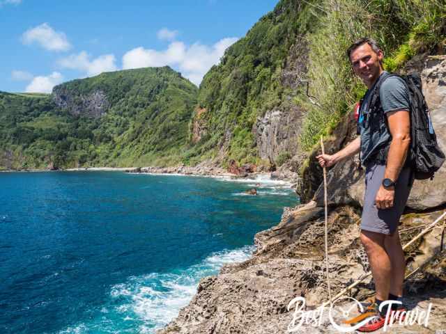 A hiker on an exposed rock at the sea.