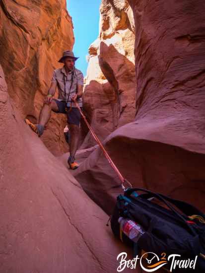 A hiker getting his backpack by rope up into the canyon