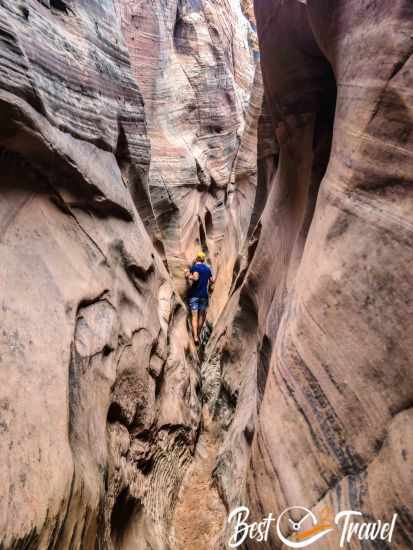 A hiker in the Zebra Slot with muddy ground