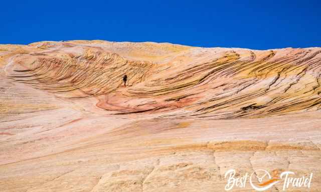 A hiker between rock formations and sandstone layers on Yellow Rock