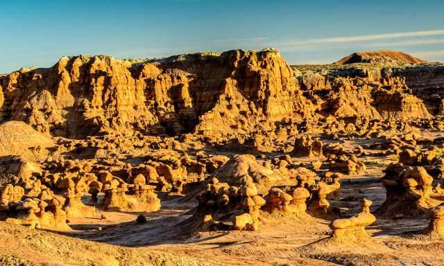 Small hoodoos and a huge wall and mountain range on the horizon