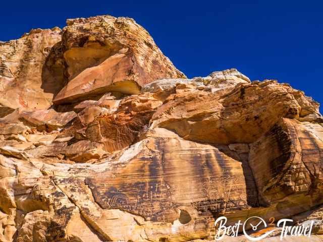 Two huge petroglyph panels high above the path with sunlight on it