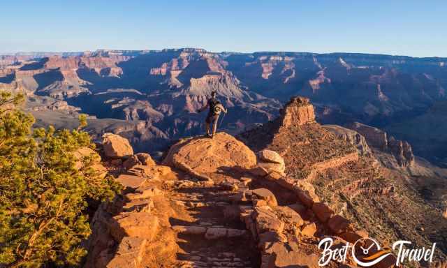 A hiker on a rock at the south Kaibab Trail looking into Grand Canyon