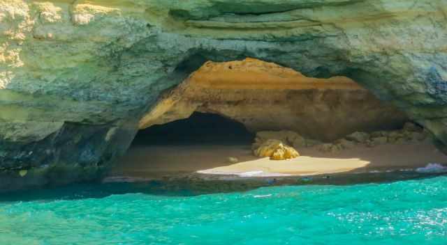 Three swimmers approaching the cave.