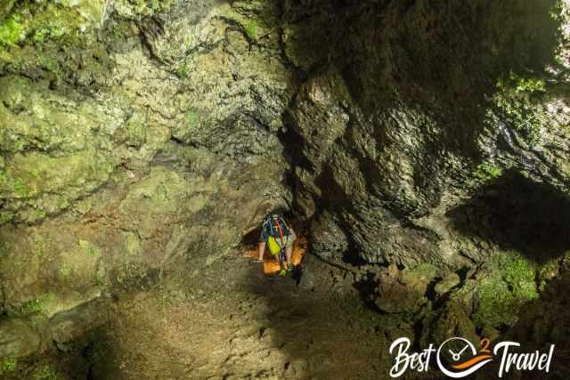 A visitor scrambles through the hole