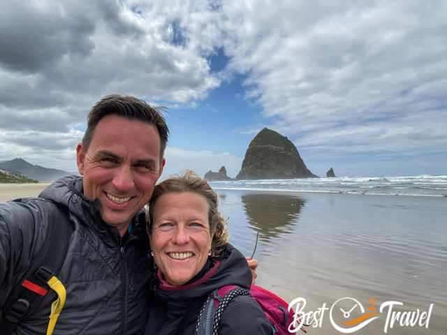 A couple at Cannon Beach with Haystack Rock in the distance