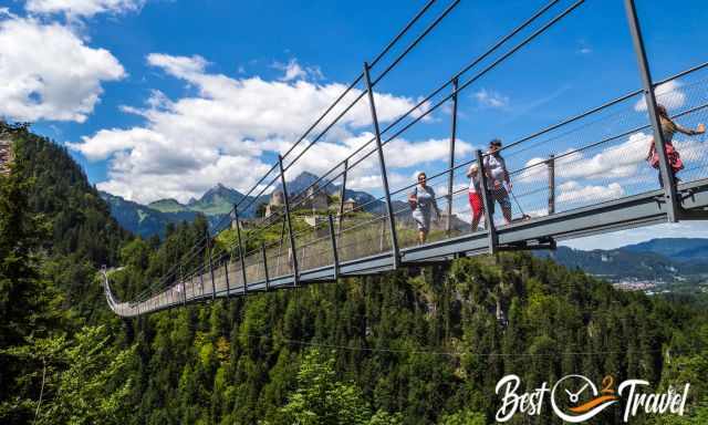 Visitors with dog on lash on the suspension bridge.