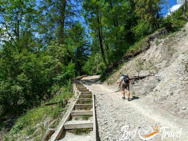 Steep forest trail on the ascent to Kührointalm and Archenkanzel, with loose gravel and wooden steps along the path.