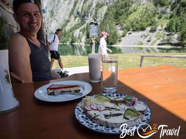 A man at Fischunkelalm enjoying a piece of cake and a buttermilk.