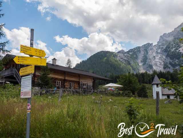 Kührointalm with its rustic wooden buildings, small chapel and trail signs set against the steep mountain backdrop.
