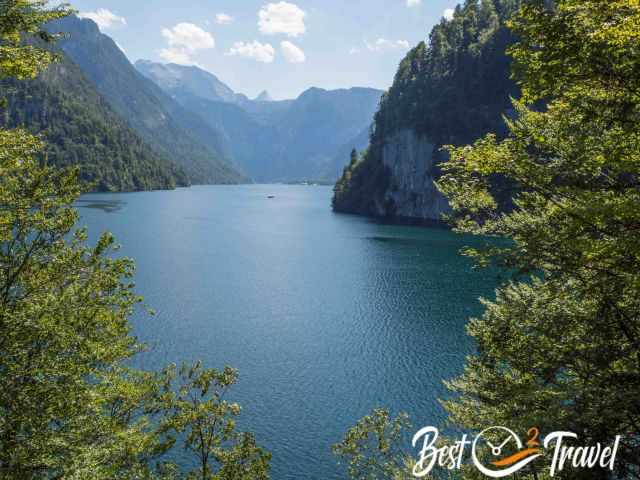 Late‑afternoon view from the Malerwinkel viewpoint with warm light on the calm lake and the steep forested mountains.