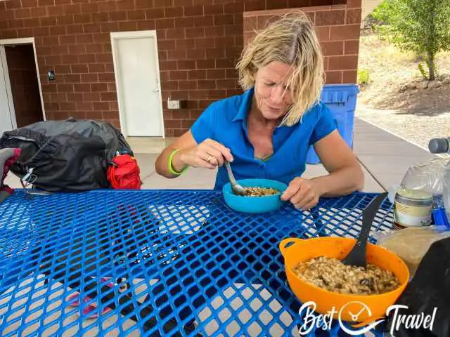 A woman eating a rice in the picnic area.