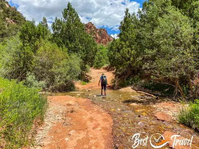 A female hiker walks through the Kanarra creek