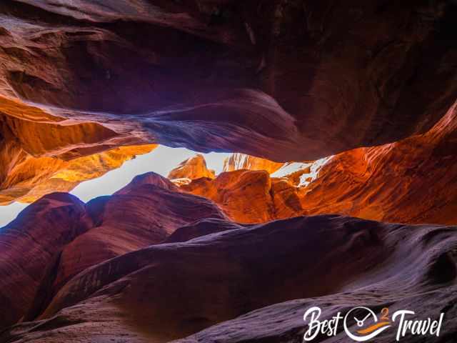 View up to the sky with the reddish, orange and lilac canyon walls.