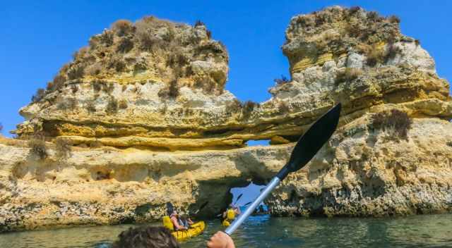 Kayak entering a rock arch.