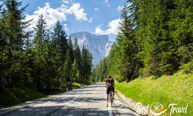 A biker on the road to Lago di Braies with Seekofel in front of him.