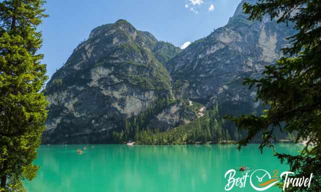 The emerald green Lake Braies shimmering in the sun with blue sky.