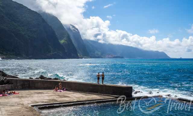 Two young men standing on a wall looking to the sea at Calamar