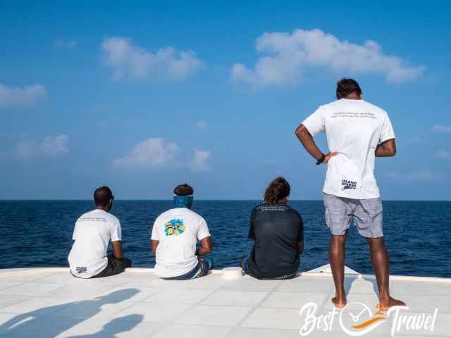 Four tour guides sitting on the top of the boat.