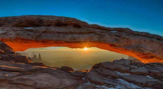 Mesa Arch with snow in winter at sunrise