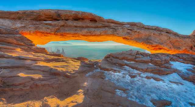 Mesa Arch with snow in winter at sunrise