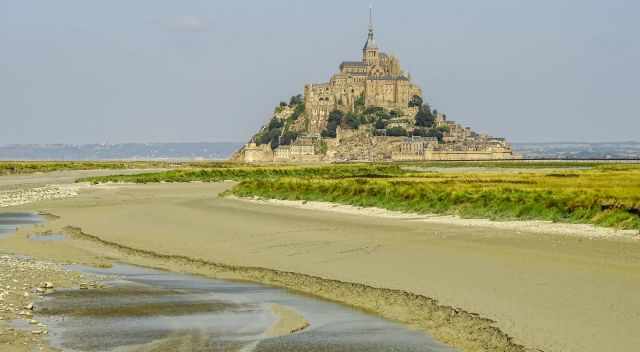 Mont Saint Michel with fresh green grass in the marshland