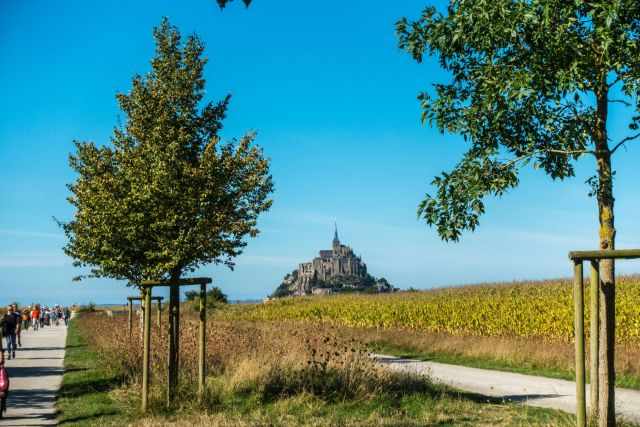 The beginning of the causeway and Mont Saint Michel in the distance on a sunny day.