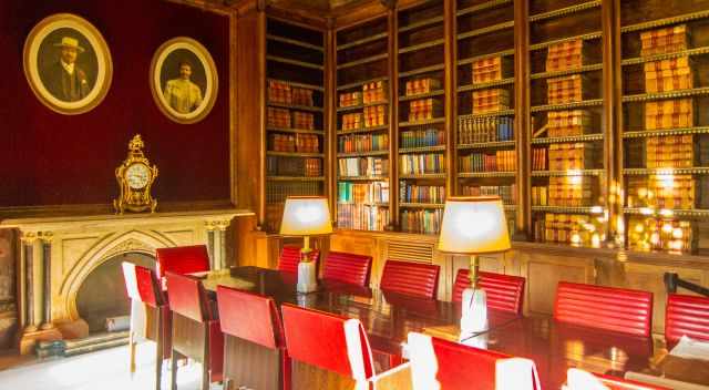 The library in the palace with a huge table and 14 chairs.